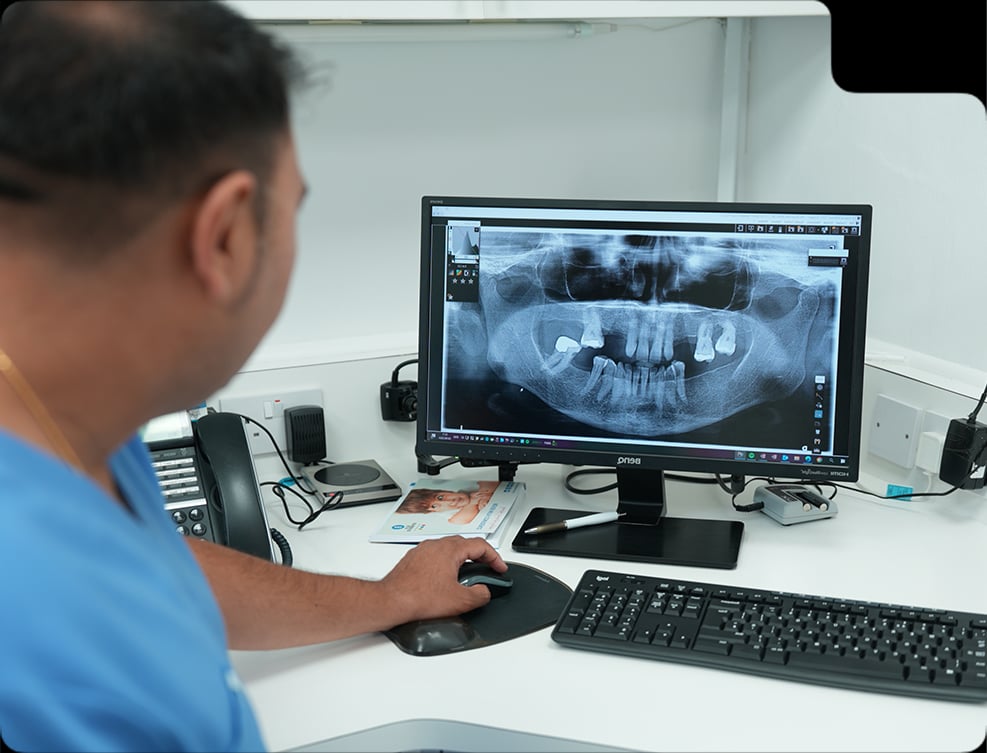 Dentist reviewing a panoramic dental X-ray for periodontal treatment planning.